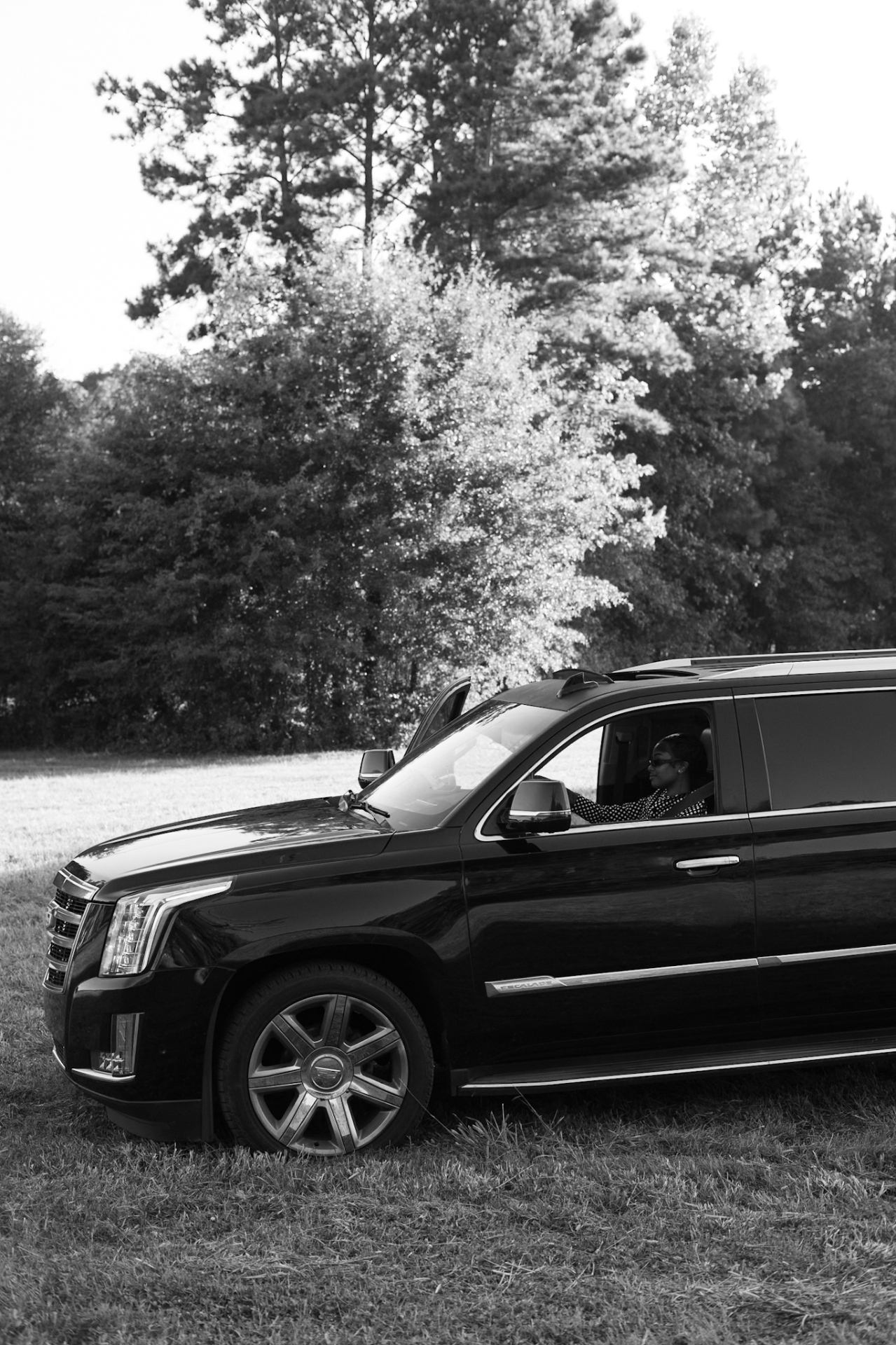 Black-and-white shot of @yammifr behind the wheel of the Escalade